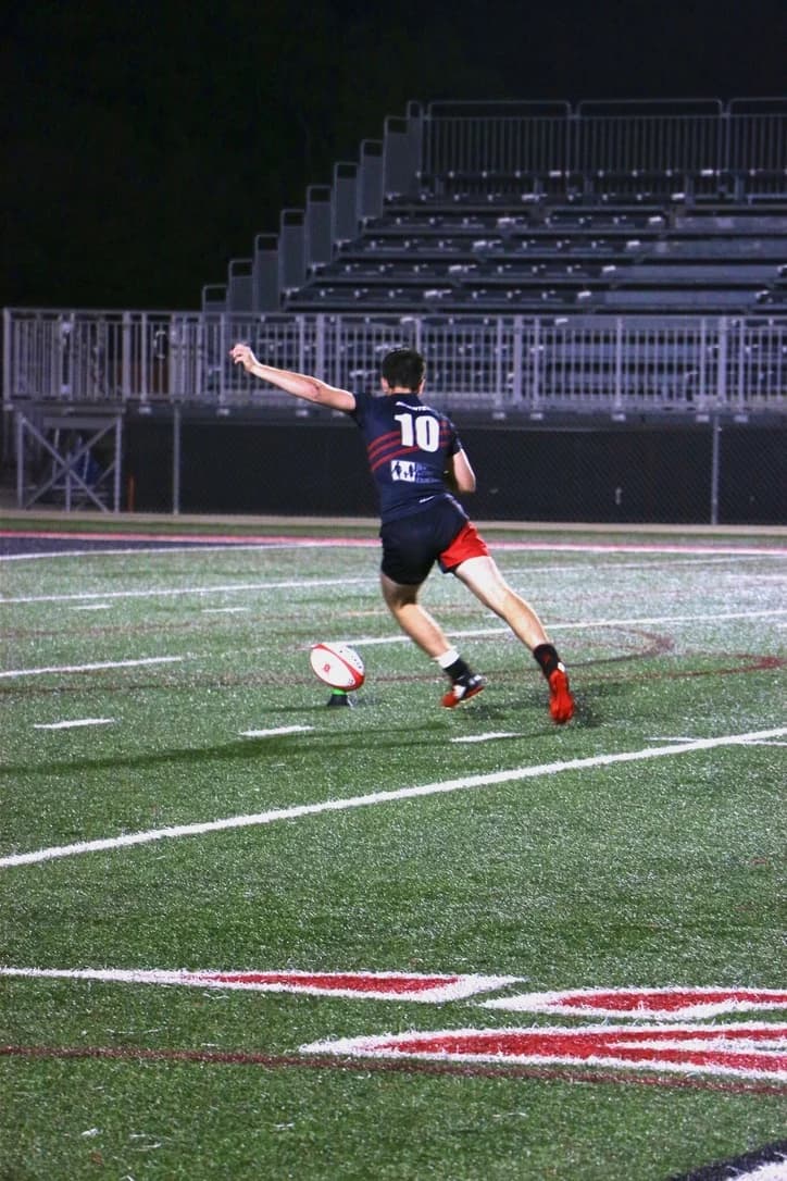 A Lake Travis player lines up a place kick under the lights.